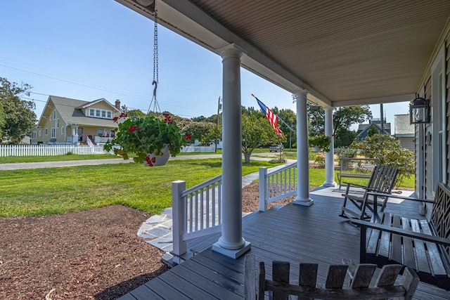 wooden terrace with covered porch and a yard