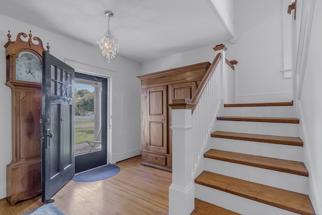 foyer with light wood-type flooring and a notable chandelier