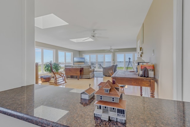 living room with a skylight, plenty of natural light, and ceiling fan