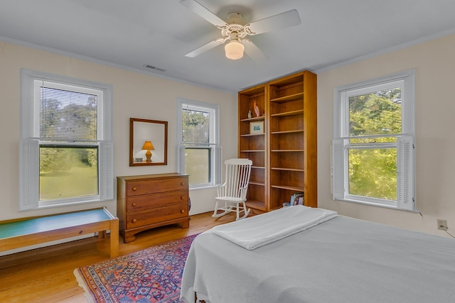19 Cedardale Ln, Irvington, VA 22480 - bedroom with wood finished floors, ornamental molding, multiple windows, and a ceiling fan