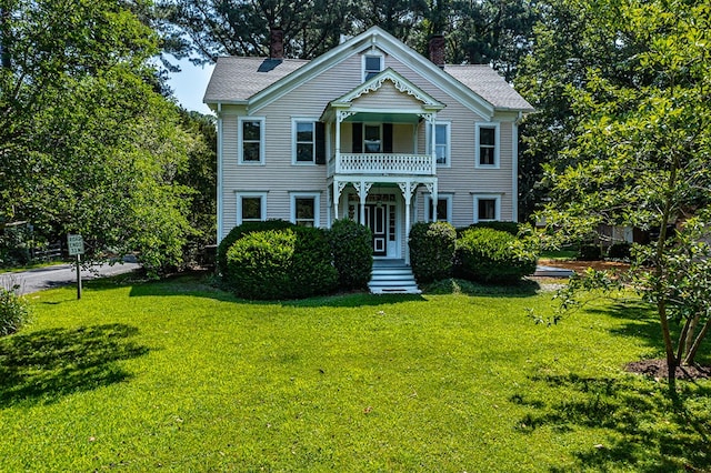 19 Cedardale Ln, Irvington, VA 22480 - view of front of house with a front yard, a balcony, and a chimney