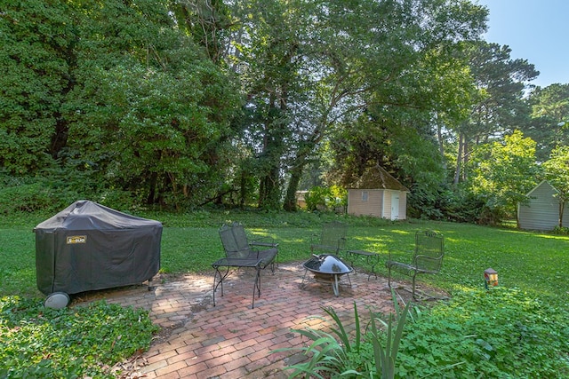 19 Cedardale Ln, Irvington, VA 22480 - view of green lawn featuring a storage unit, an outdoor fire pit, and a patio area