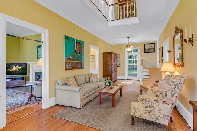 19 Cedardale Ln, Irvington, VA 22480 - living room with hardwood / wood-style flooring, ornamental molding, a warm lit fireplace, stairs, and a ceiling fan