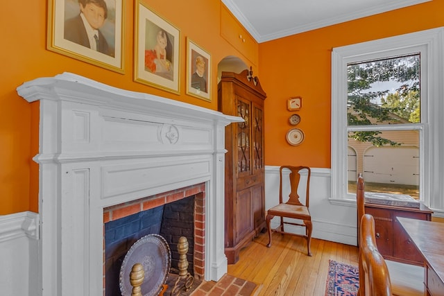 19 Cedardale Ln, Irvington, VA 22480 - sitting room featuring a brick fireplace, wainscoting, light wood-style floors, and ornamental molding