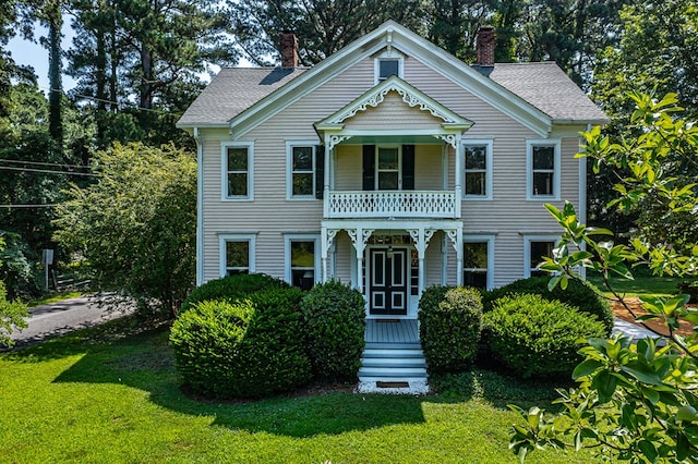 19 Cedardale Ln, Irvington, VA 22480 - victorian-style house featuring a balcony, a chimney, and a front yard