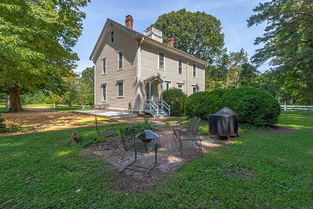19 Cedardale Ln, Irvington, VA 22480 - back of house with a chimney, a lawn, and a patio