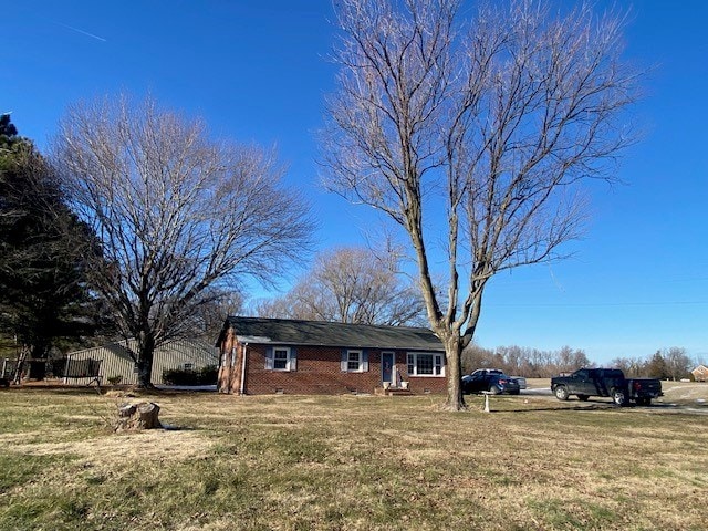 view of front of property featuring a front lawn and brick siding