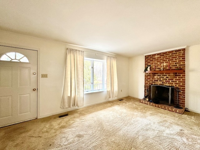 unfurnished living room featuring carpet floors and a brick fireplace