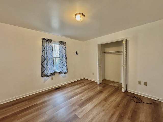 unfurnished bedroom with wood-type flooring and a closet