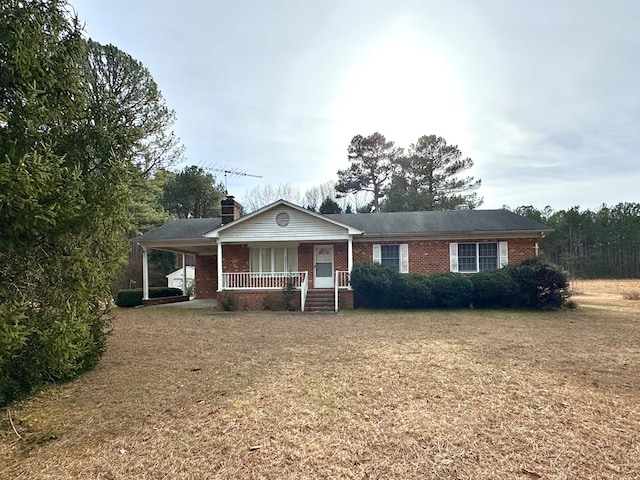 ranch-style house with covered porch and a front lawn