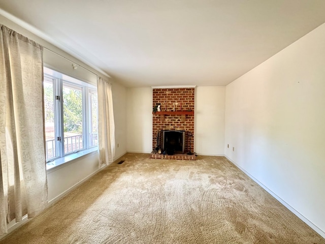 unfurnished living room with a fireplace and carpet