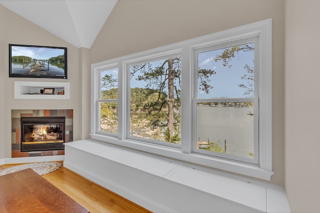 interior details with a tile fireplace and wood finished floors