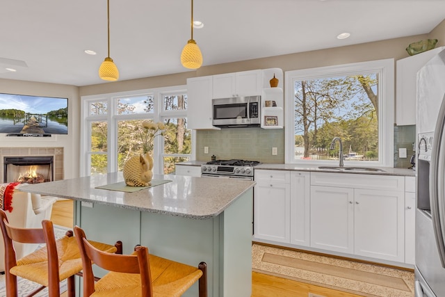 kitchen with decorative backsplash, white cabinetry, a kitchen bar, and appliances with stainless steel finishes