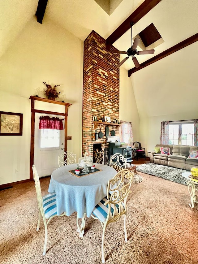 dining area featuring carpet, ceiling fan, beam ceiling, and high vaulted ceiling