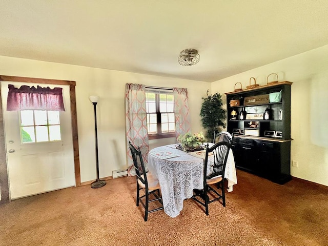 carpeted dining room with a baseboard heating unit