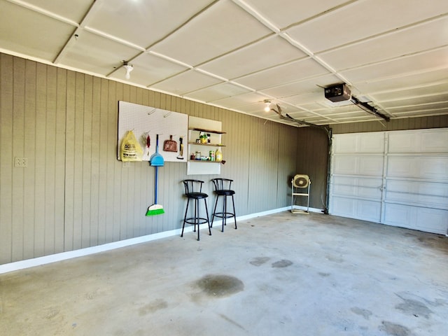 garage featuring wooden walls and a garage door opener