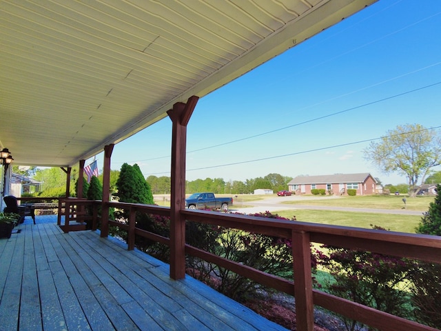 wooden terrace with a porch and a yard