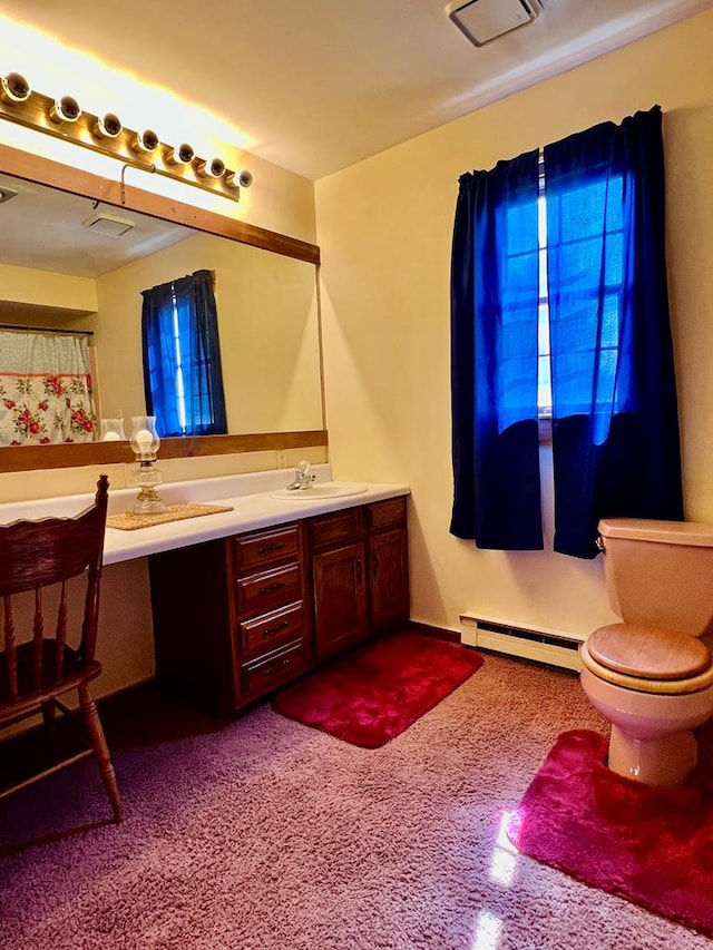 bathroom with vanity, toilet, and a baseboard heating unit