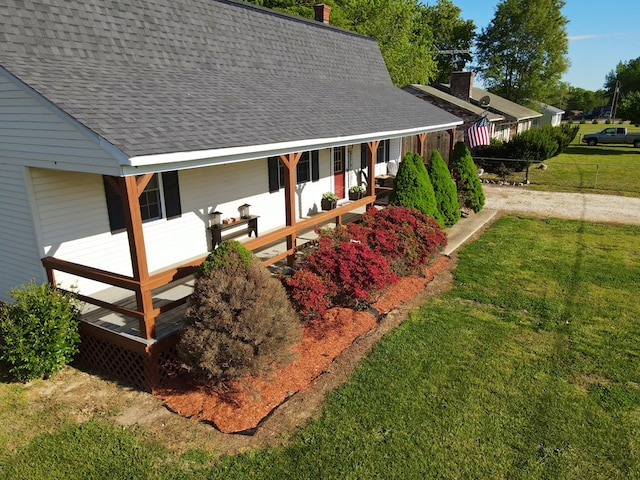 exterior space with covered porch and a yard