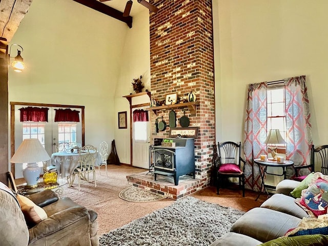 living room featuring carpet, a high ceiling, a wood stove, and beam ceiling