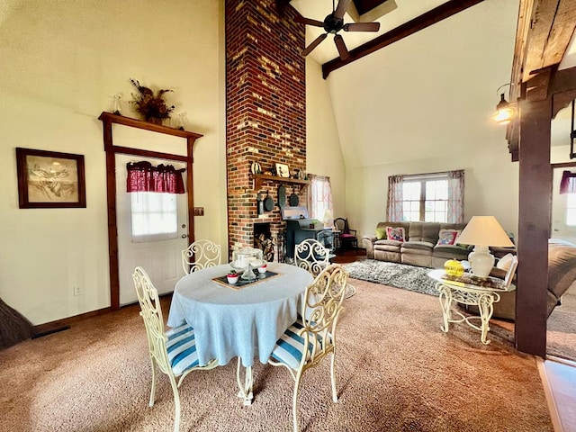 dining space featuring carpet, ceiling fan, beamed ceiling, and high vaulted ceiling