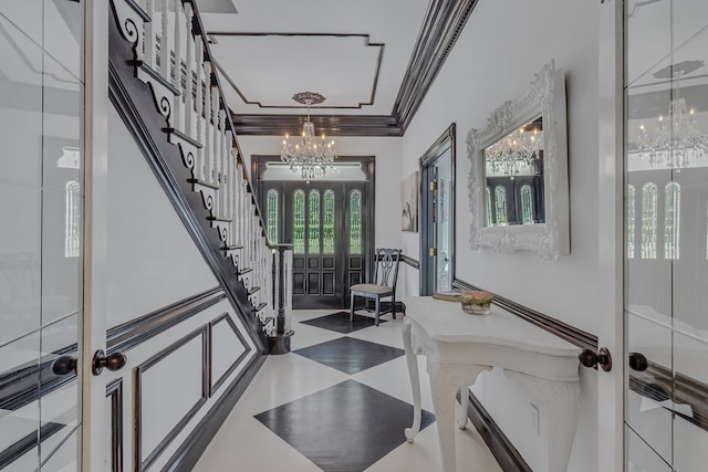 foyer featuring stairway, a chandelier, crown molding, and french doors