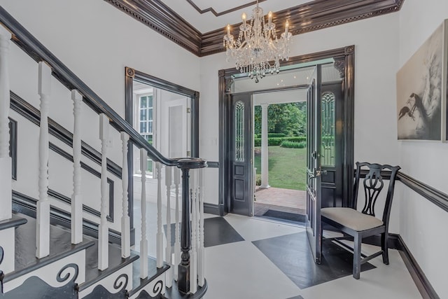 foyer featuring ornamental molding, a chandelier, baseboards, and stairs