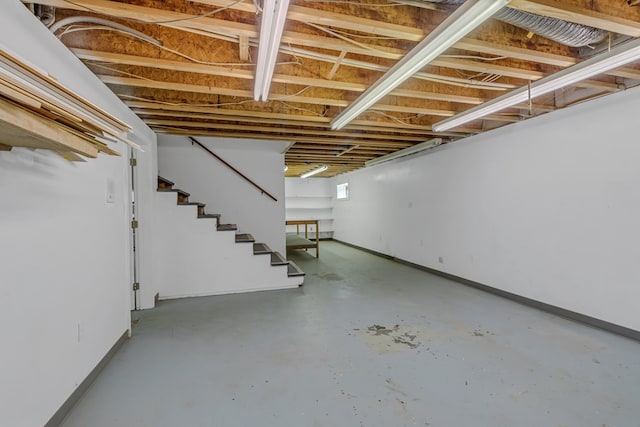 basement featuring stairs and baseboards