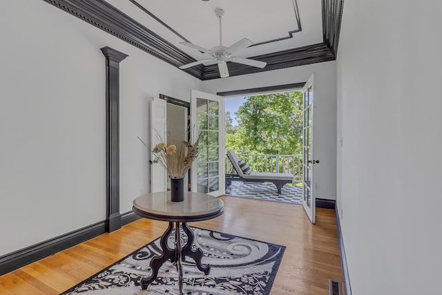 interior space featuring crown molding, visible vents, ceiling fan, wood finished floors, and baseboards