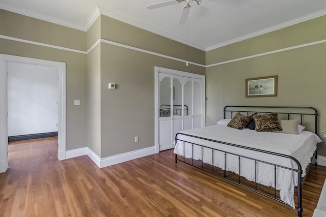 unfurnished bedroom featuring ceiling fan, ornamental molding, wood finished floors, and baseboards