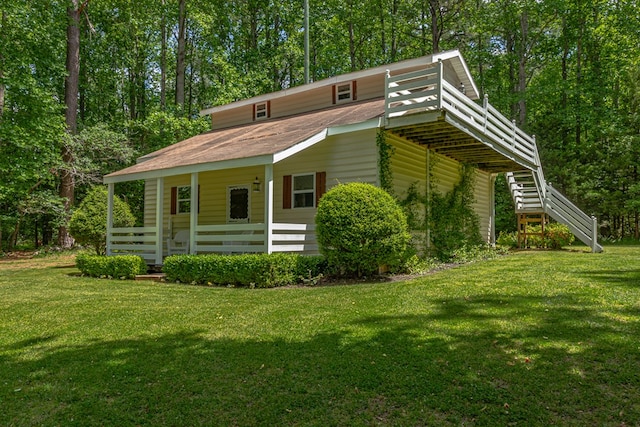 view of front of home with stairs, a porch, and a front yard