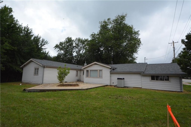 back of property with a lawn and a wooden deck