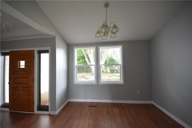 foyer entrance with a notable chandelier, dark wood-type flooring, and lofted ceiling