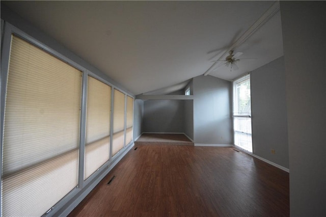 empty room with ceiling fan, lofted ceiling, and dark hardwood / wood-style floors