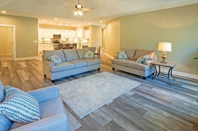 living room featuring ceiling fan and light wood-type flooring