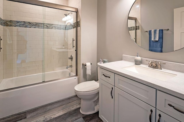 full bathroom featuring toilet, combined bath / shower with glass door, oversized vanity, and wood-type flooring