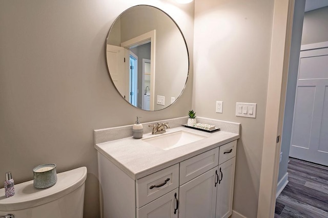 bathroom featuring hardwood / wood-style flooring, toilet, and vanity