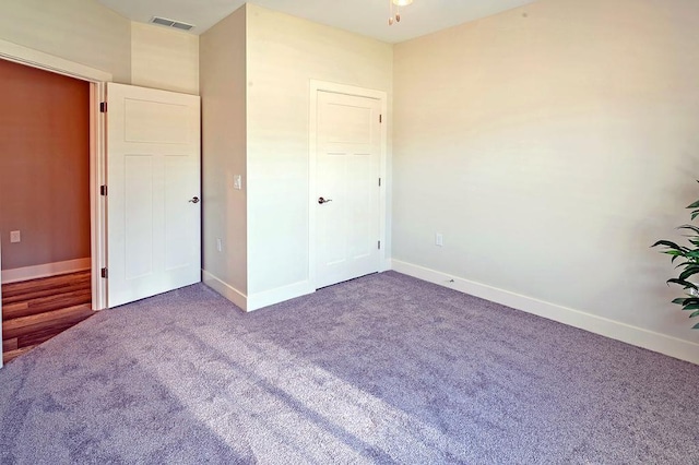 unfurnished bedroom featuring dark carpet