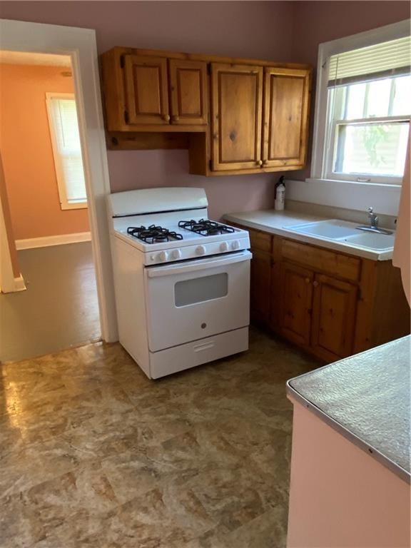 kitchen featuring tile floors, sink, and white gas stove