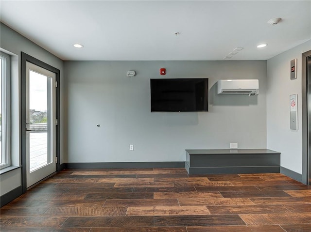 unfurnished living room featuring a wall mounted air conditioner and dark hardwood / wood-style floors