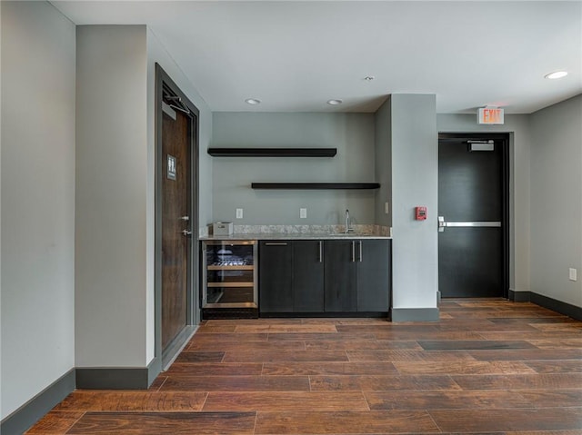 interior space with beverage cooler, dark hardwood / wood-style floors, and sink