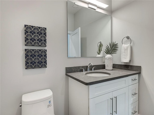 bathroom with vanity with extensive cabinet space and toilet