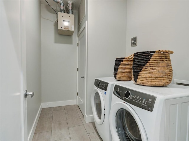 laundry room featuring light tile flooring and washer and clothes dryer