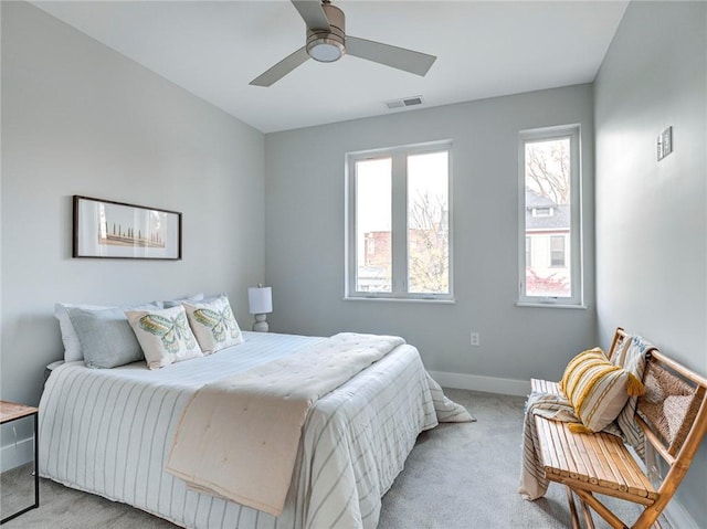 carpeted bedroom with multiple windows and ceiling fan