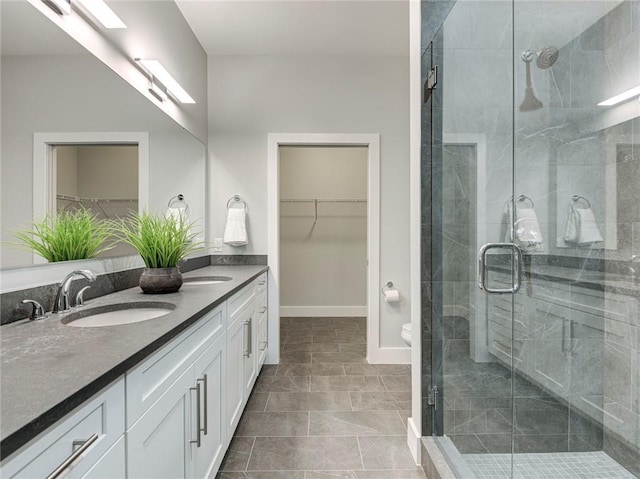 bathroom with toilet, tile floors, an enclosed shower, and vanity