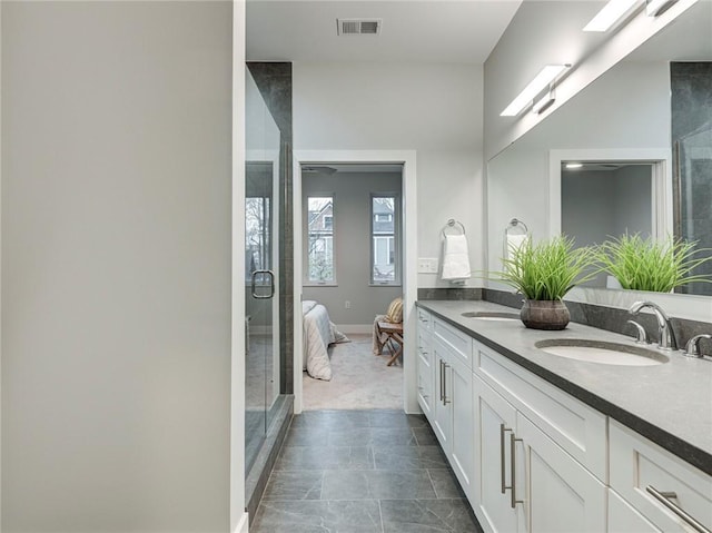 bathroom featuring double sink, tile floors, a shower with shower door, and vanity with extensive cabinet space