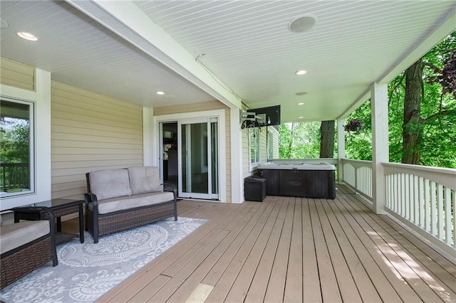 deck with an outdoor living space and a hot tub