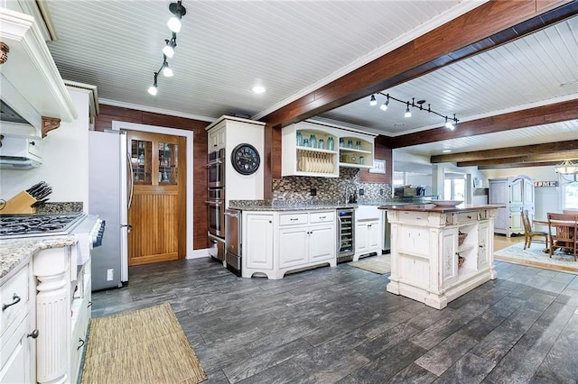 kitchen with a center island, beverage cooler, white cabinets, stainless steel appliances, and dark hardwood / wood-style flooring