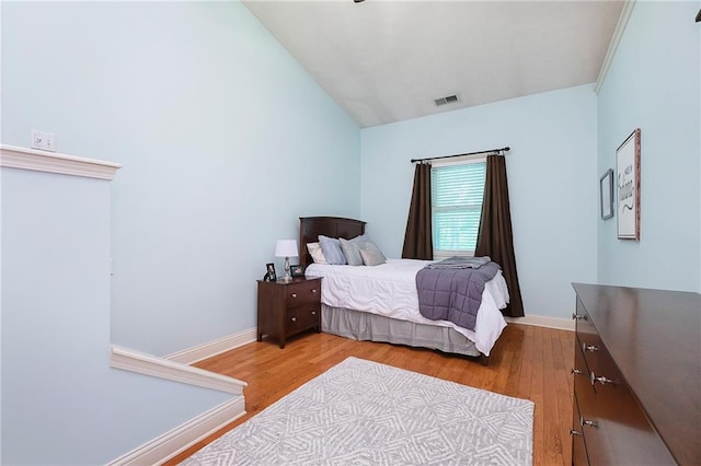 bedroom with lofted ceiling and hardwood / wood-style flooring