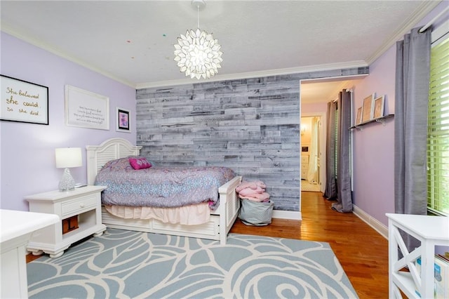 bedroom with hardwood / wood-style floors, ornamental molding, and a chandelier